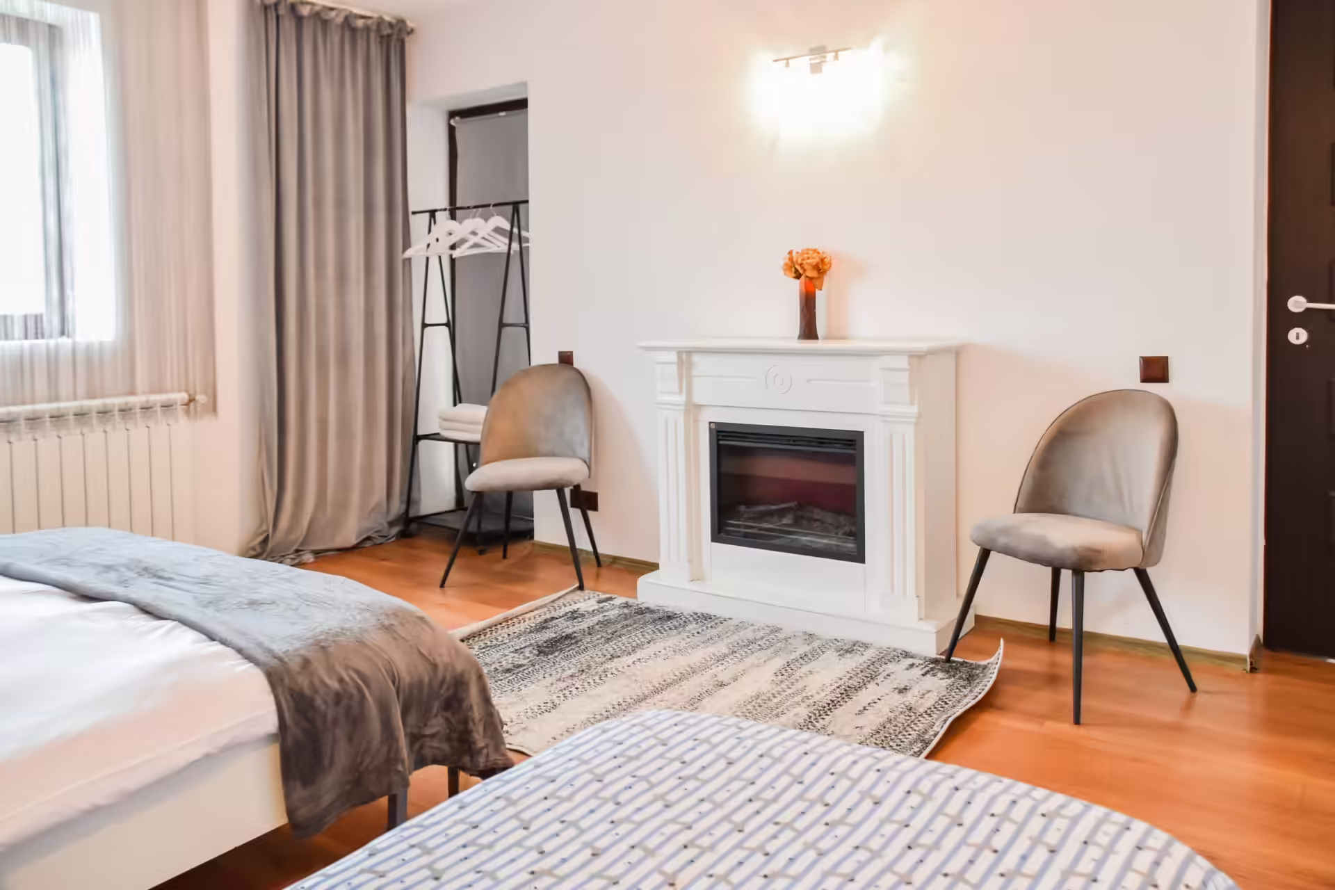 Dormitor cu șemineu decorativ și covor la Vila Mik Guesthouse Dormitor cu șemineu decorativ și covor la Vila Mik Guesthouse