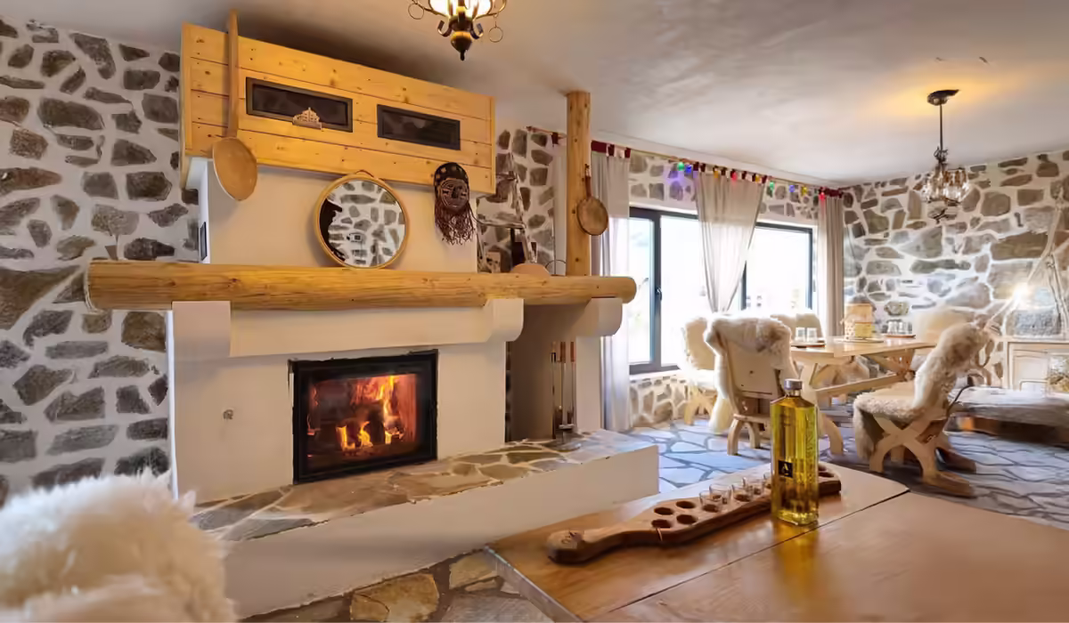 Șemineu rustic-modern în livingul Cabanei Alaska din Rânca