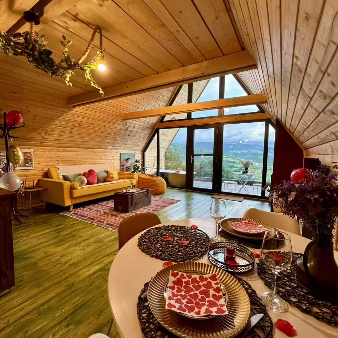 Living luminos în cabana A-frame, cu masă pregătită, la La Noi La Munte Living luminos în cabana A-frame, cu masă pregătită, la La Noi La Munte