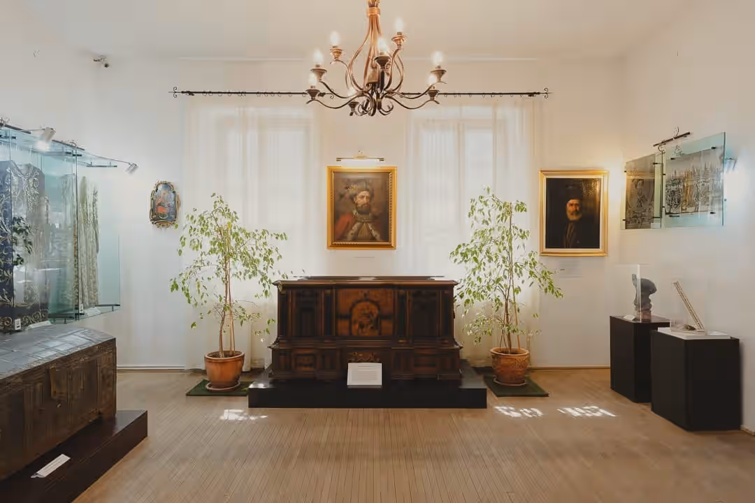 Sala de expoziție din Muzeul Casa Domnească Brebu cu portrete domnești și lada de zestre