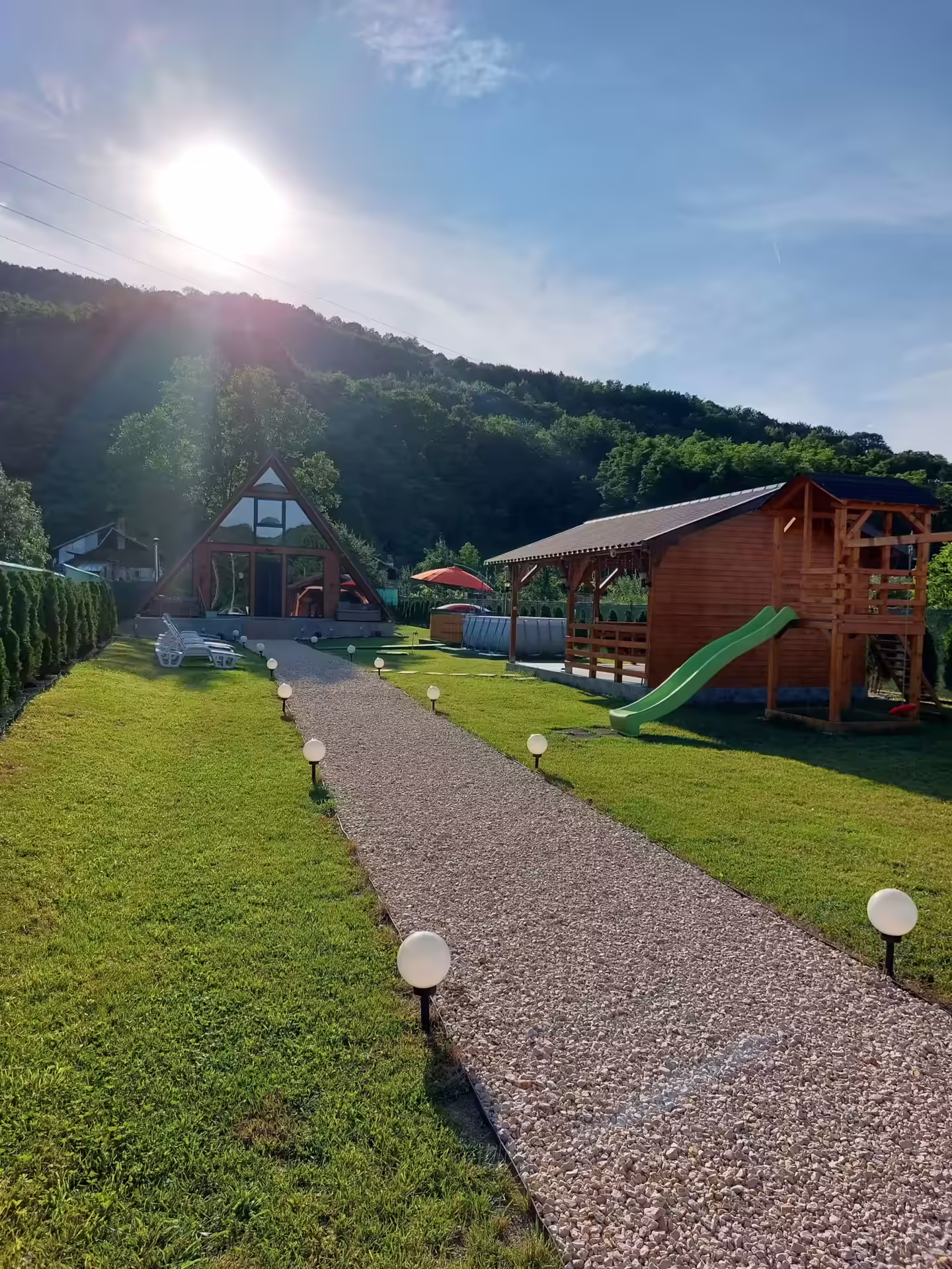 Curte cu alee, gazon și tobogan pentru copii la Cabana A-frame Nis Curte cu alee, gazon și tobogan pentru copii la Cabana A-frame Nis