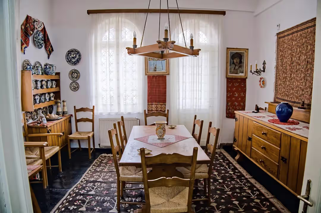 Sufrageria cu mobilier din lemn și farfurii pictate din Muzeul Cezar Petrescu Sufrageria cu mobilier din lemn și farfurii pictate din Muzeul Cezar Petrescu