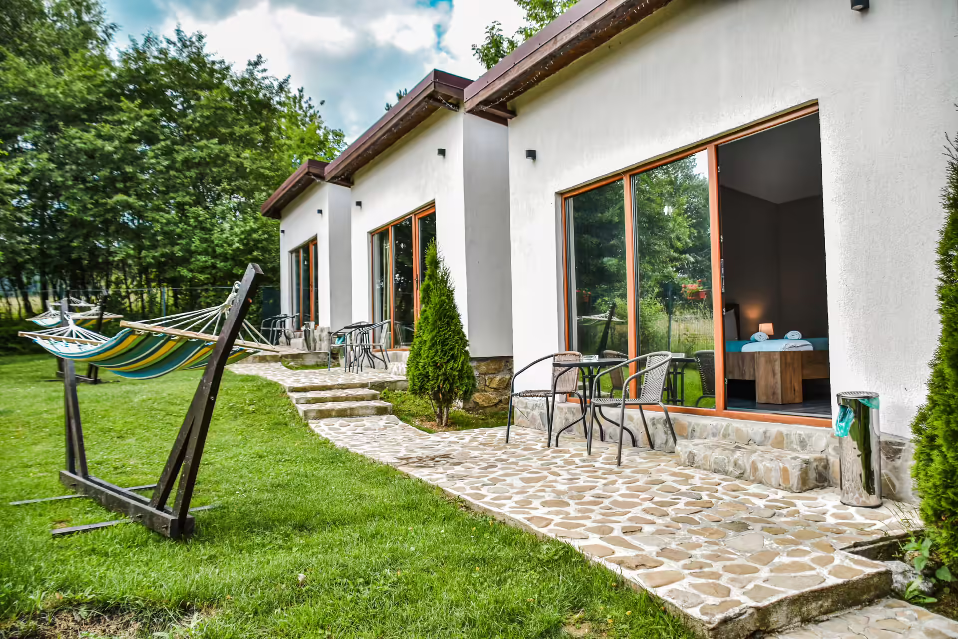 Terasa unui bungalou cu hamac și grădină însorită la Silver Bungalow