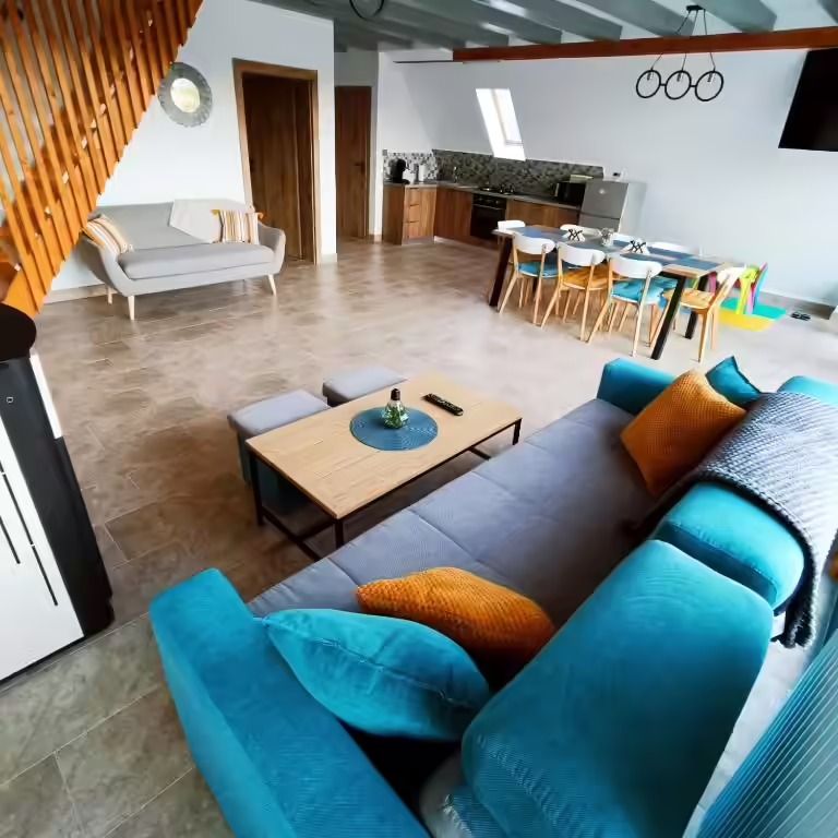 Living cu canapea turcoaz și scară din lemn la Cabana A-frame Nis Living cu canapea turcoaz și scară din lemn la Cabana A-frame Nis