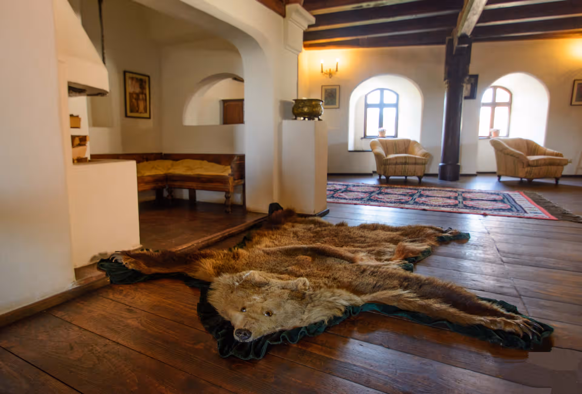 Salon cu blană de urs pe podea și ferestre arcuite în Castelul Bran Salon cu blană de urs pe podea și ferestre arcuite în Castelul Bran