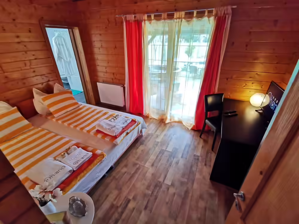 Cameră finisată în lemn, cu pat dublu și acces la balcon la Ohana Boutique Hotel