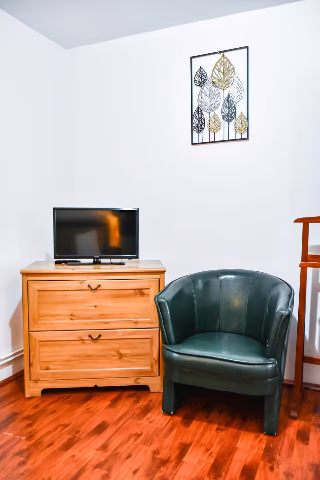 Cameră cu fotoliu verde și televizor la Casa Georgea din Săcele