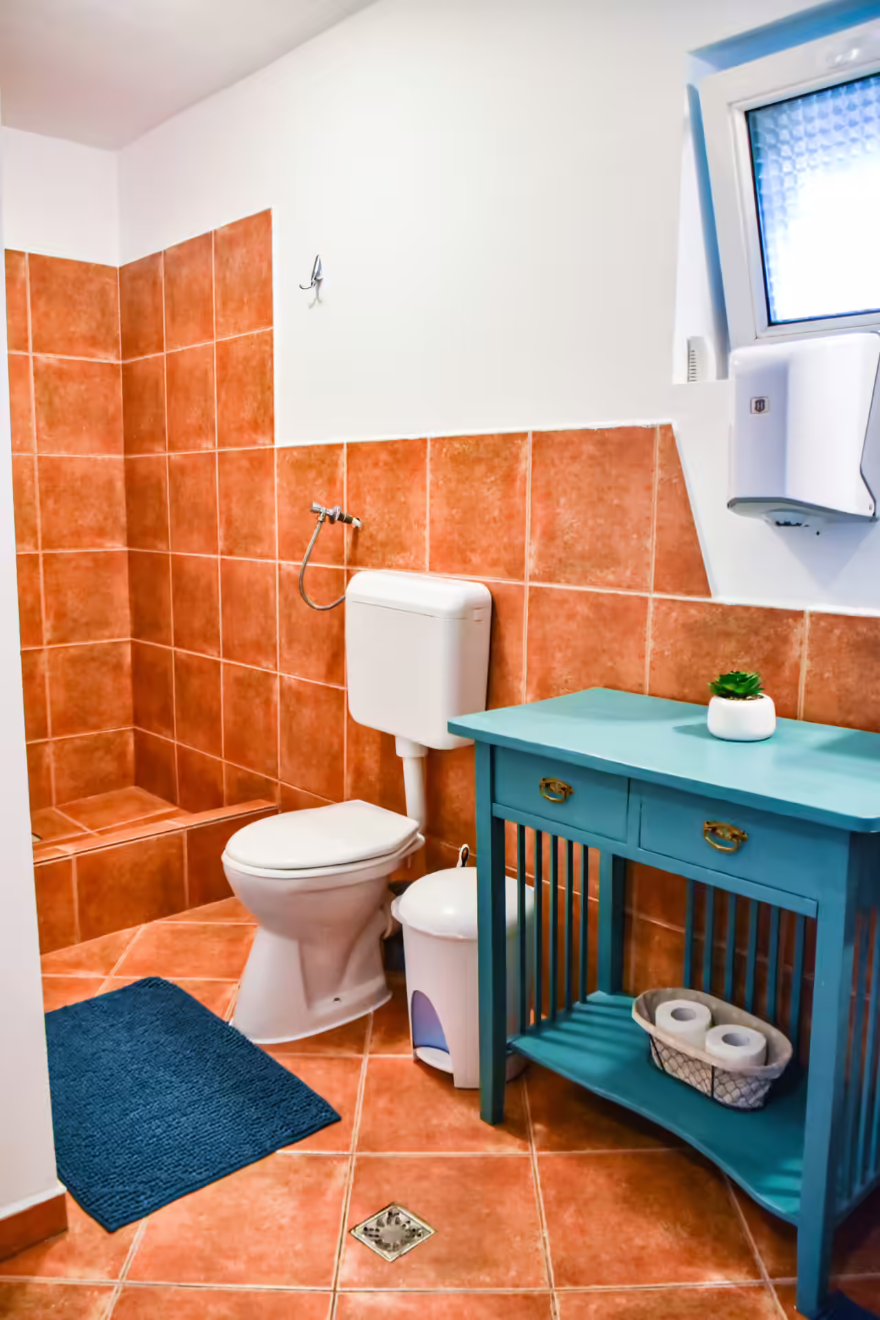 Baie cu mobilier turcoaz și faianță teracotă la Casa Georgea