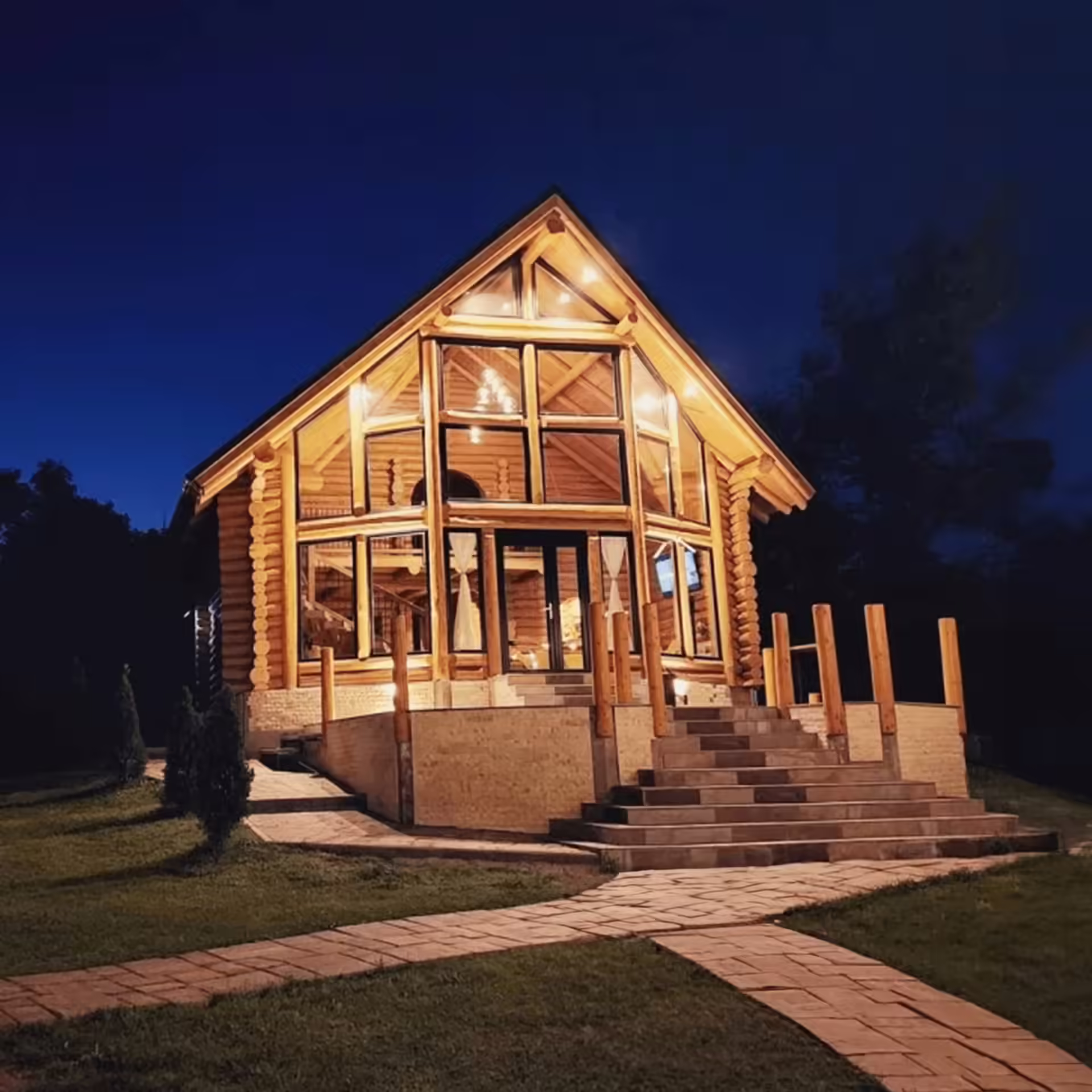 Cabana Cacica Hill din Bucovina, exterior seara cu fațade mari de sticlă iluminate Cabana Cacica Hill din Bucovina, exterior seara cu fațade mari de sticlă iluminate