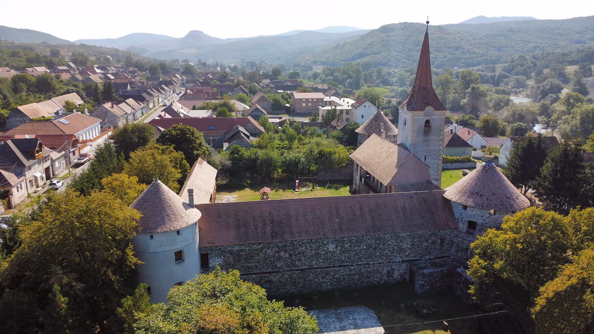 Vedere aeriană asupra Castelului Sükösd Bethlen și bisericii din Racoș Vedere aeriană asupra Castelului Sükösd Bethlen și bisericii din Racoș
