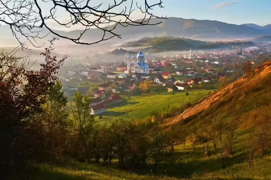 Panoramă de toamnă peste satul și dealurile din Maramureș