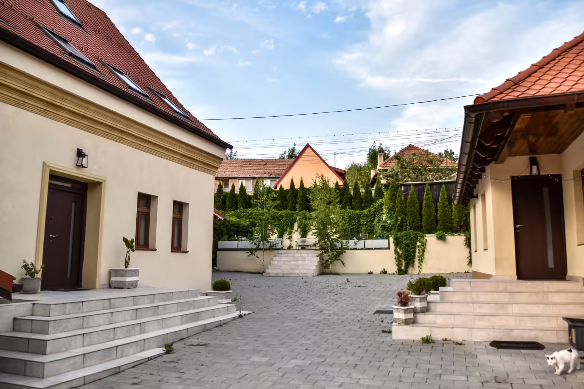 Curtea pavată a vilei Berg House 31 din Săcele, cu gard viu și spațiu de parcare Curtea pavată a vilei Berg House 31 din Săcele, cu gard viu și spațiu de parcare