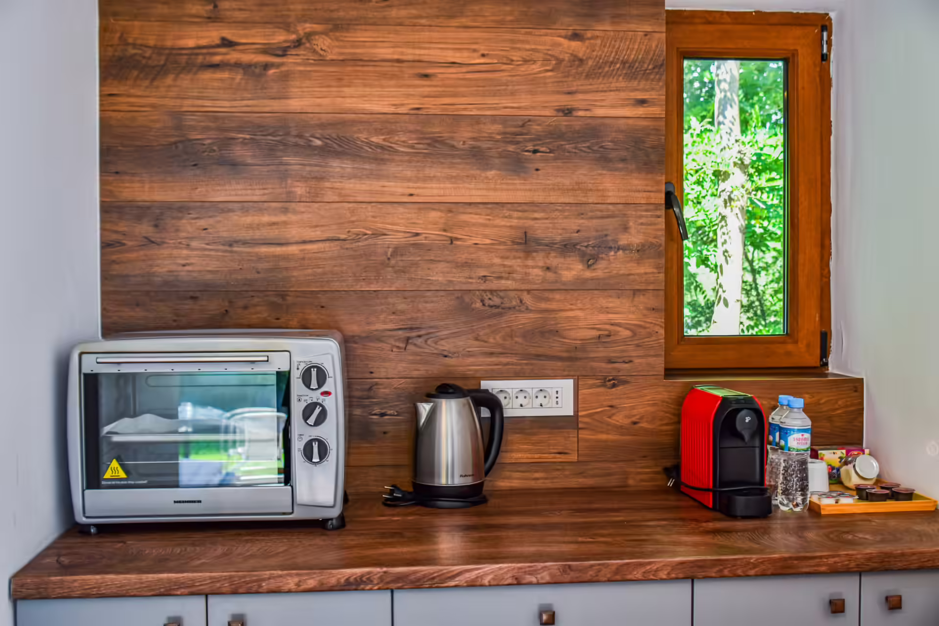 Chicinetă cu cuptor electric și espressor pe perete din lemn