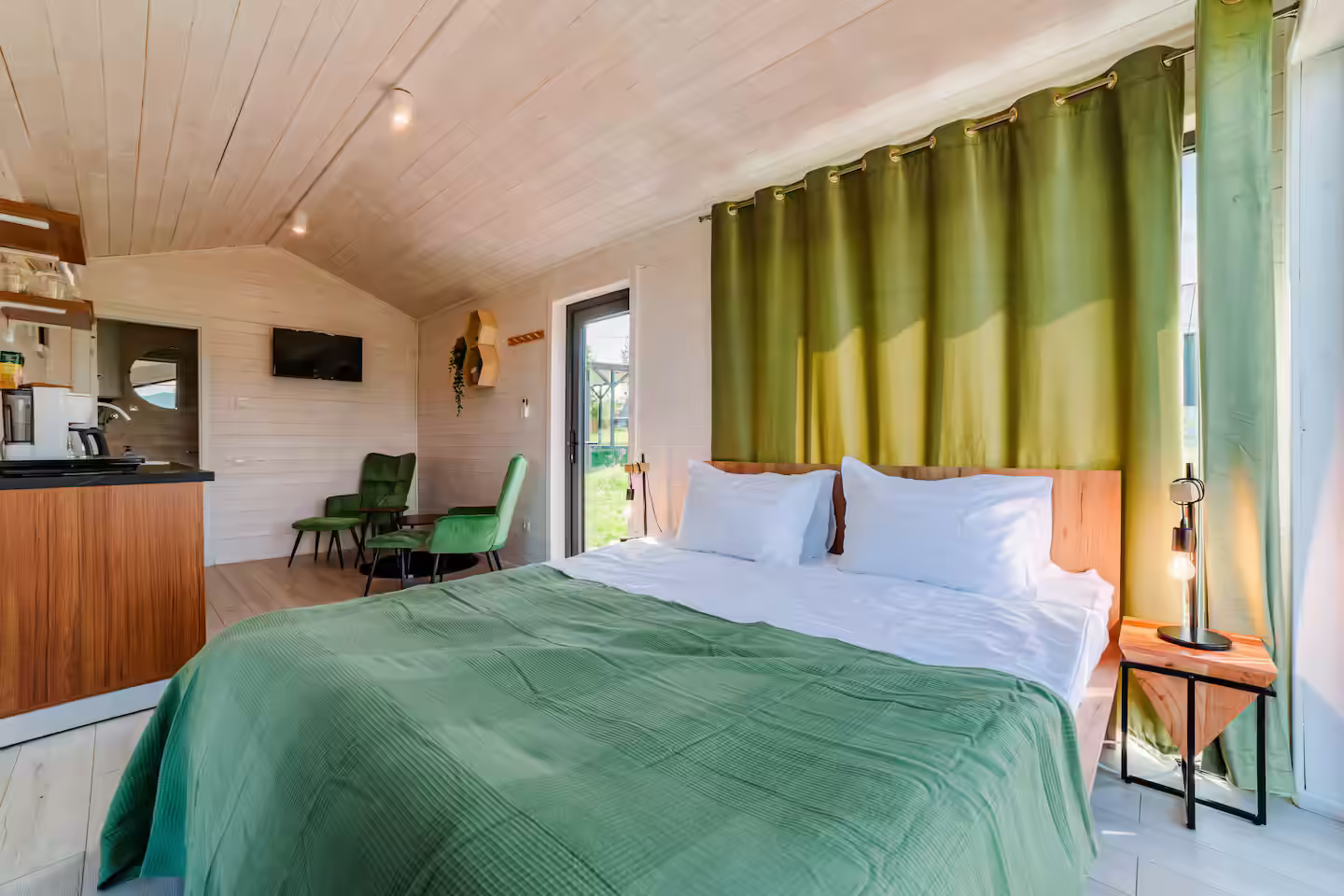 Dormitor cu pat dublu și perdele verzi în cabana SkyAtlas Hideaway, Bran Dormitor cu pat dublu și perdele verzi în cabana SkyAtlas Hideaway, Bran
