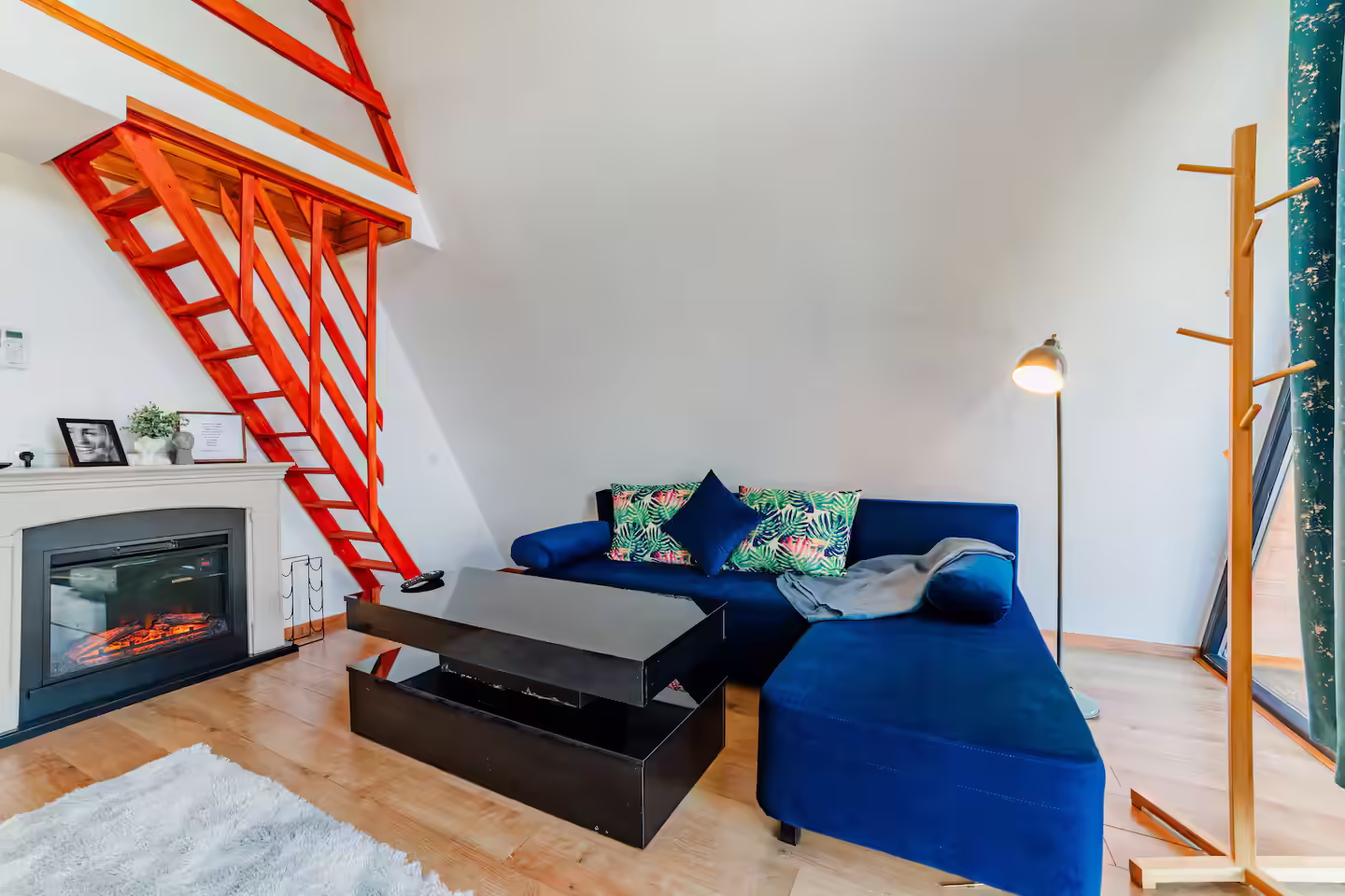 Living în cabana Stoic A-frame de la SkyAtlas Hideaway, cu canapea albastră și zonă de relaxare Living în cabana Stoic A-frame de la SkyAtlas Hideaway, cu canapea albastră și zonă de relaxare