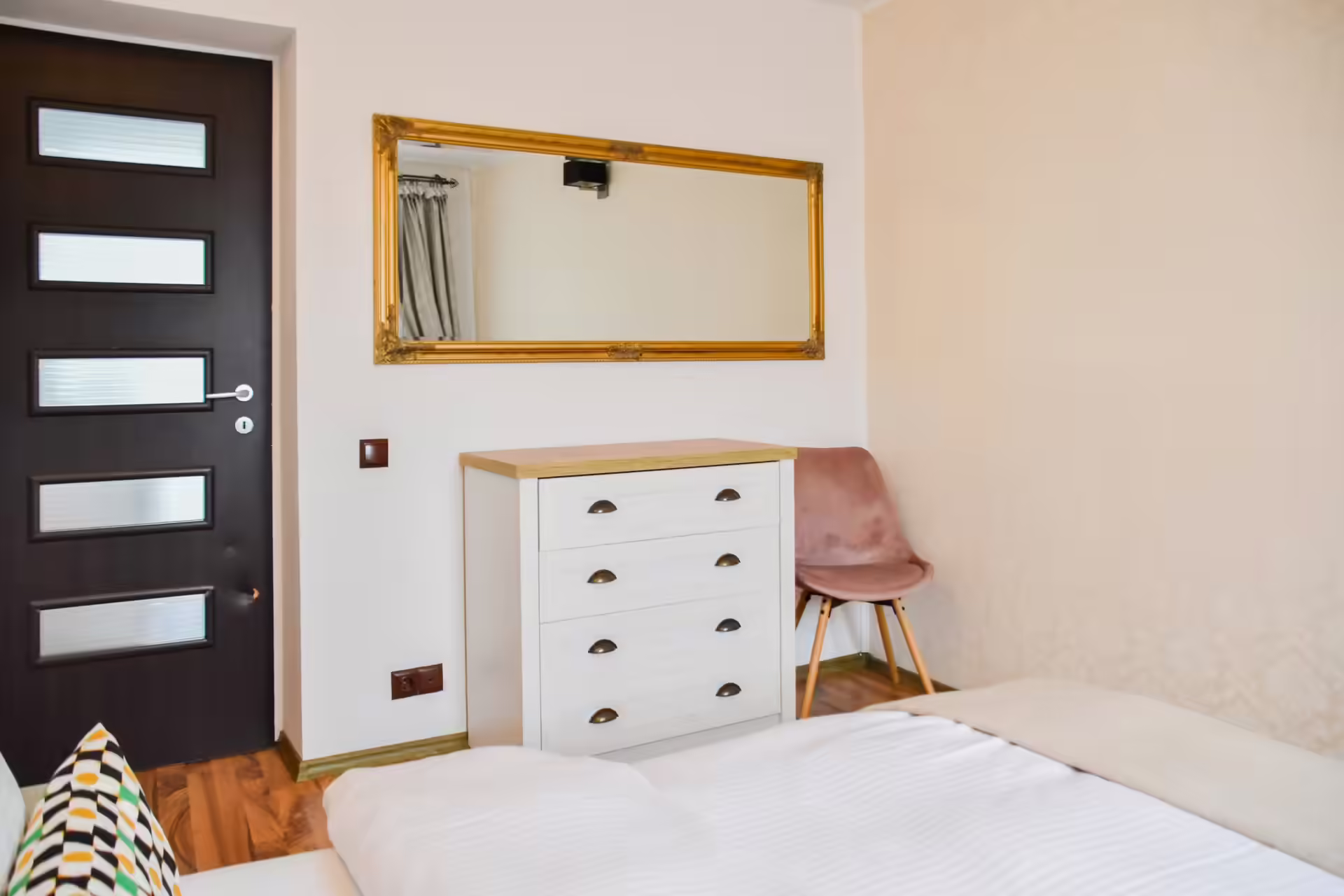 Dormitor cu comodă și oglindă cu ramă aurie la Vila Mik Guesthouse Dormitor cu comodă și oglindă cu ramă aurie la Vila Mik Guesthouse
