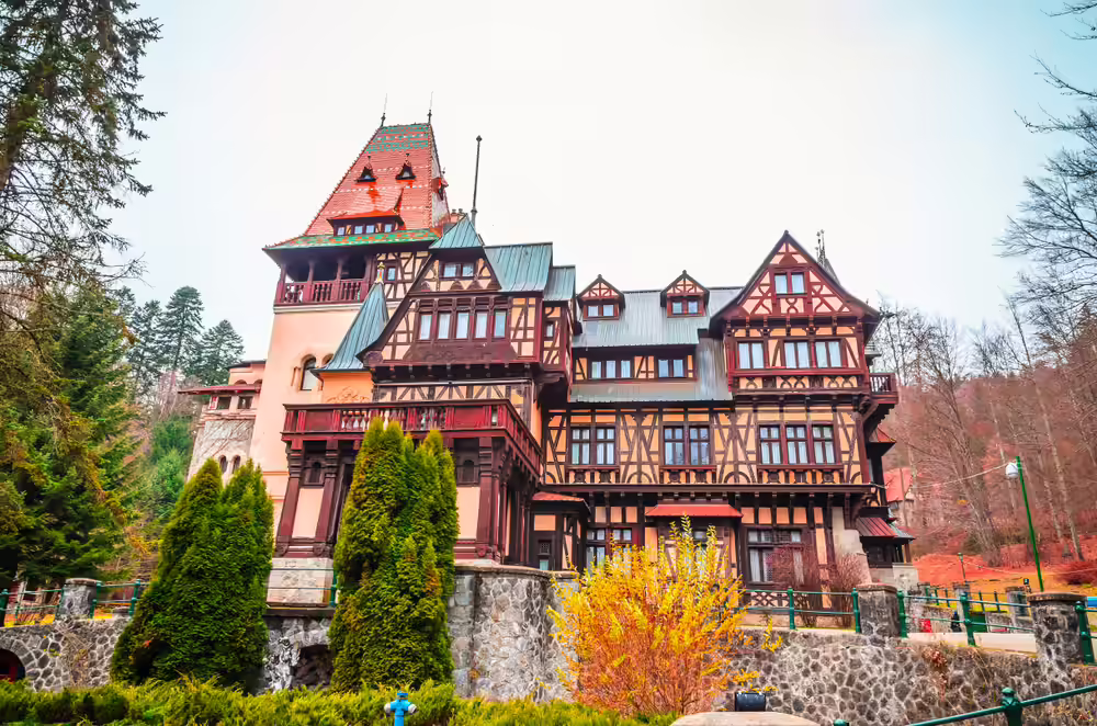 Castelul Pelișor primăvara, cu grădina înflorită și arbuști galbeni Castelul Pelișor primăvara, cu grădina înflorită și arbuști galbeni