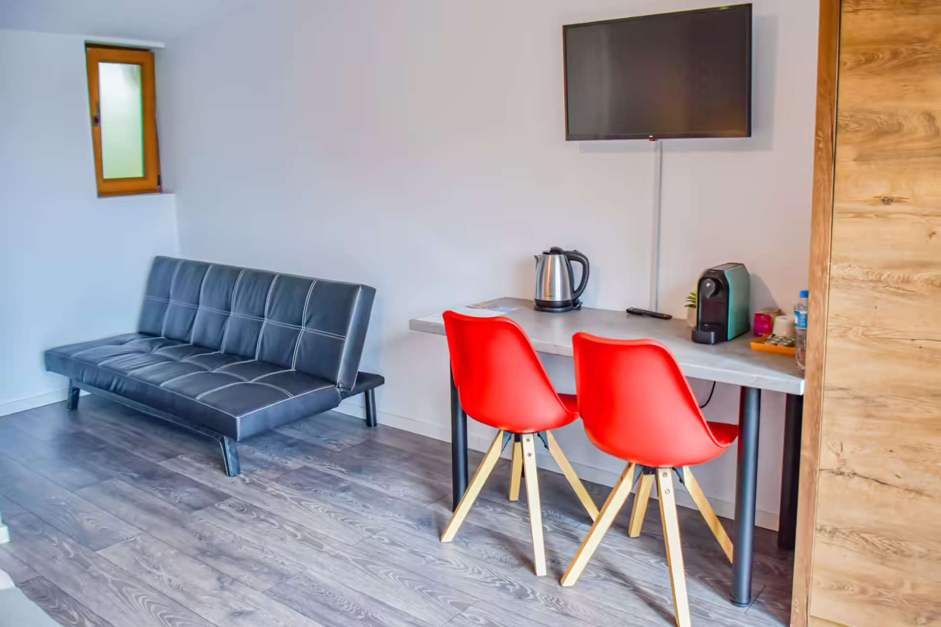 Zonă de living cu canapea, televizor și masă într-un bungalou Silver Bungalow