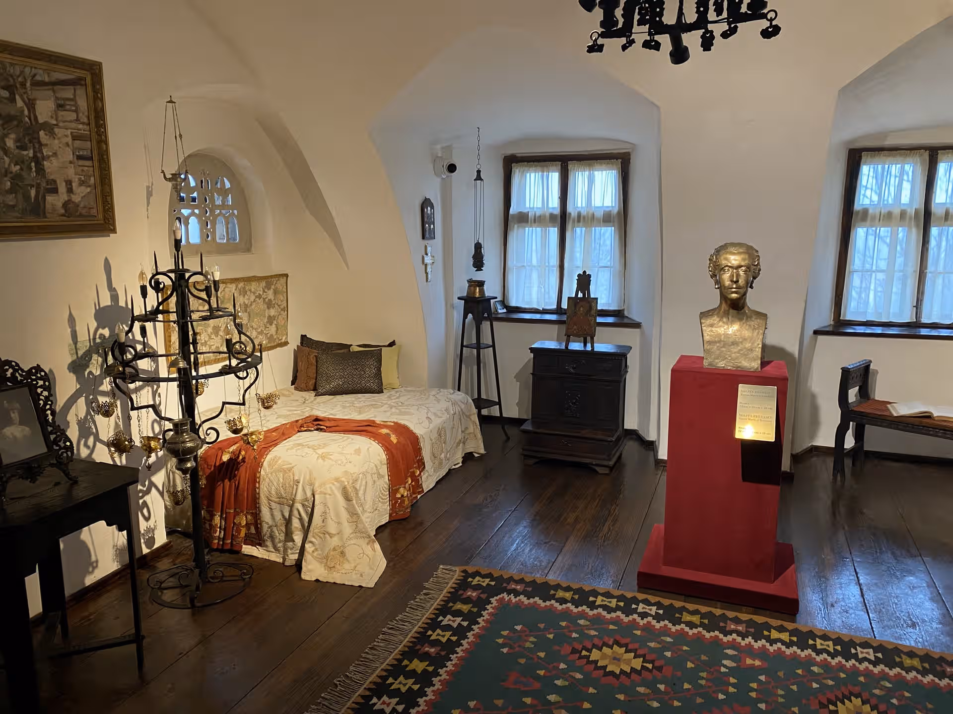 Dormitor cu pat istoric și bust pe soclu roșu în Castelul Bran Dormitor cu pat istoric și bust pe soclu roșu în Castelul Bran