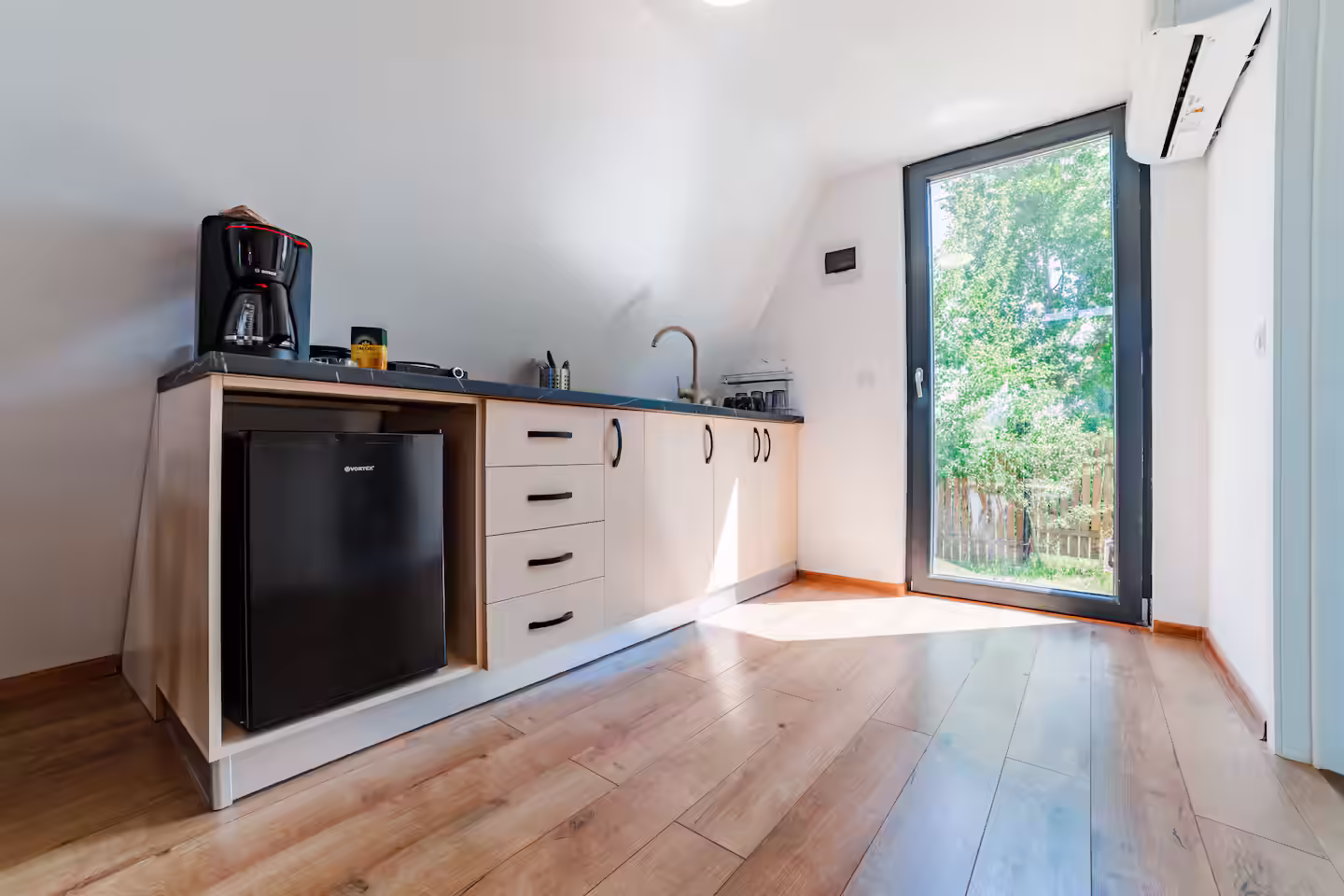 Bucătărie modernă cu frigider și dulapuri albe în cabana SkyAtlas Hideaway din Bran Bucătărie modernă cu frigider și dulapuri albe în cabana SkyAtlas Hideaway din Bran