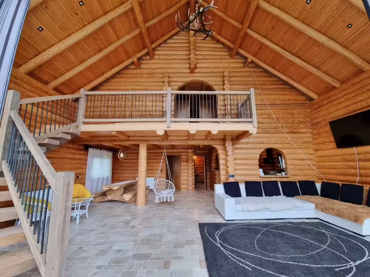 Living înalt cu șemineu și mezanin deschis la Cabana Cacica Hill Living înalt cu șemineu și mezanin deschis la Cabana Cacica Hill