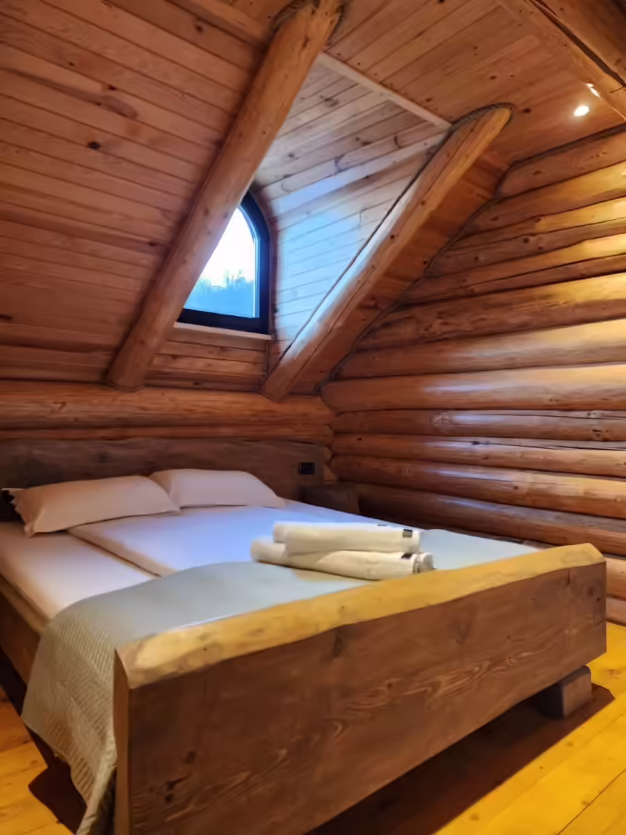 Dormitor cu pat din lemn masiv și fereastră de mansardă la Cacica Hill Dormitor cu pat din lemn masiv și fereastră de mansardă la Cacica Hill