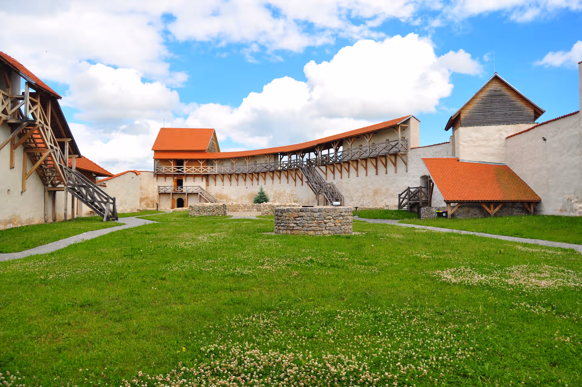Curtea largă cu iarbă a Cetății Feldioara și turnurile restaurate Curtea largă cu iarbă a Cetății Feldioara și turnurile restaurate
