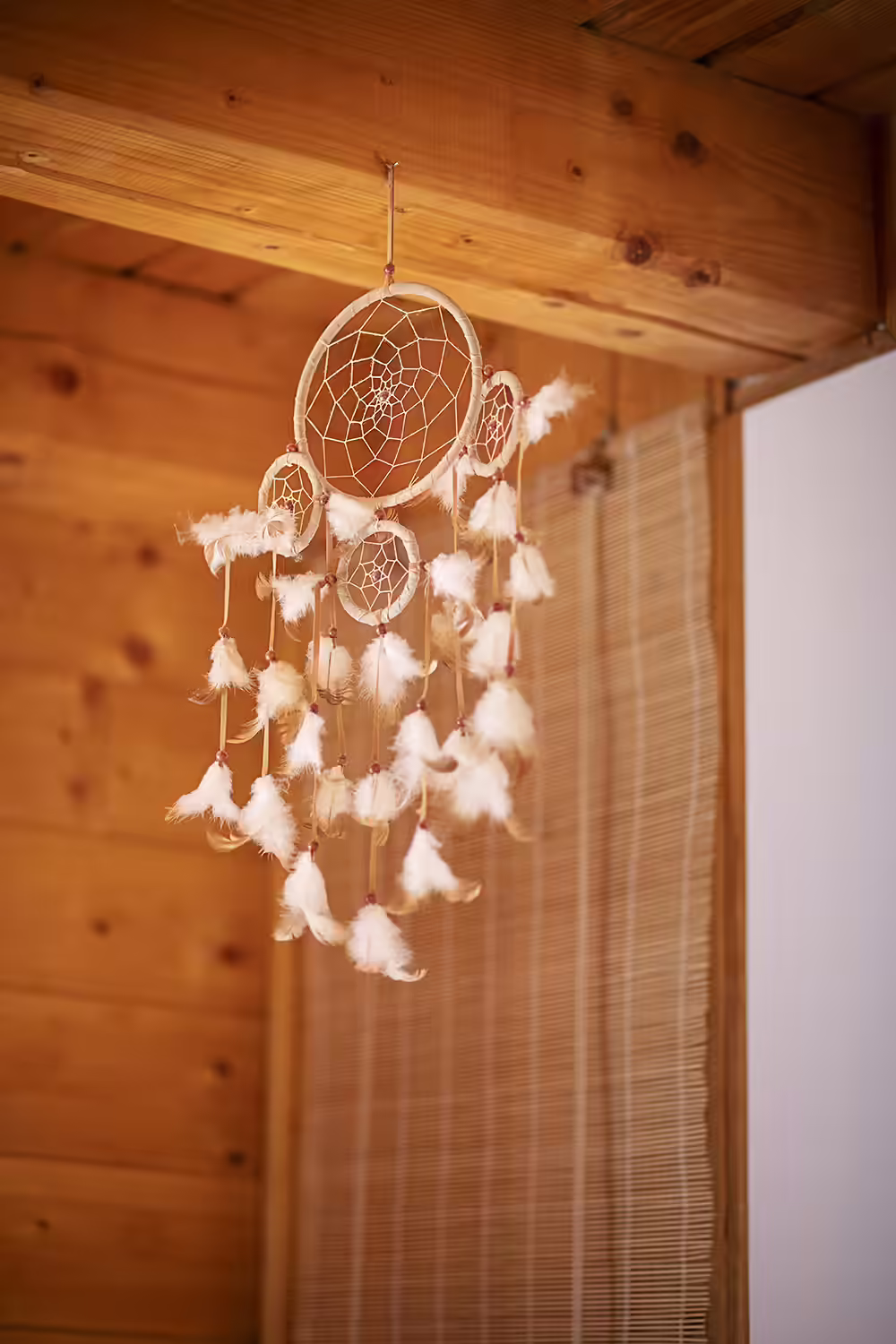 Decor interior cu prinzător de vise pe peretele din lemn la Ohana Boutique Hotel