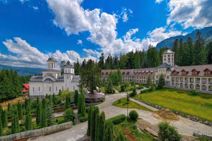 Vedere de ansamblu a Mănăstirii Caraiman cu gazon și alei Vedere de ansamblu a Mănăstirii Caraiman cu gazon și alei
