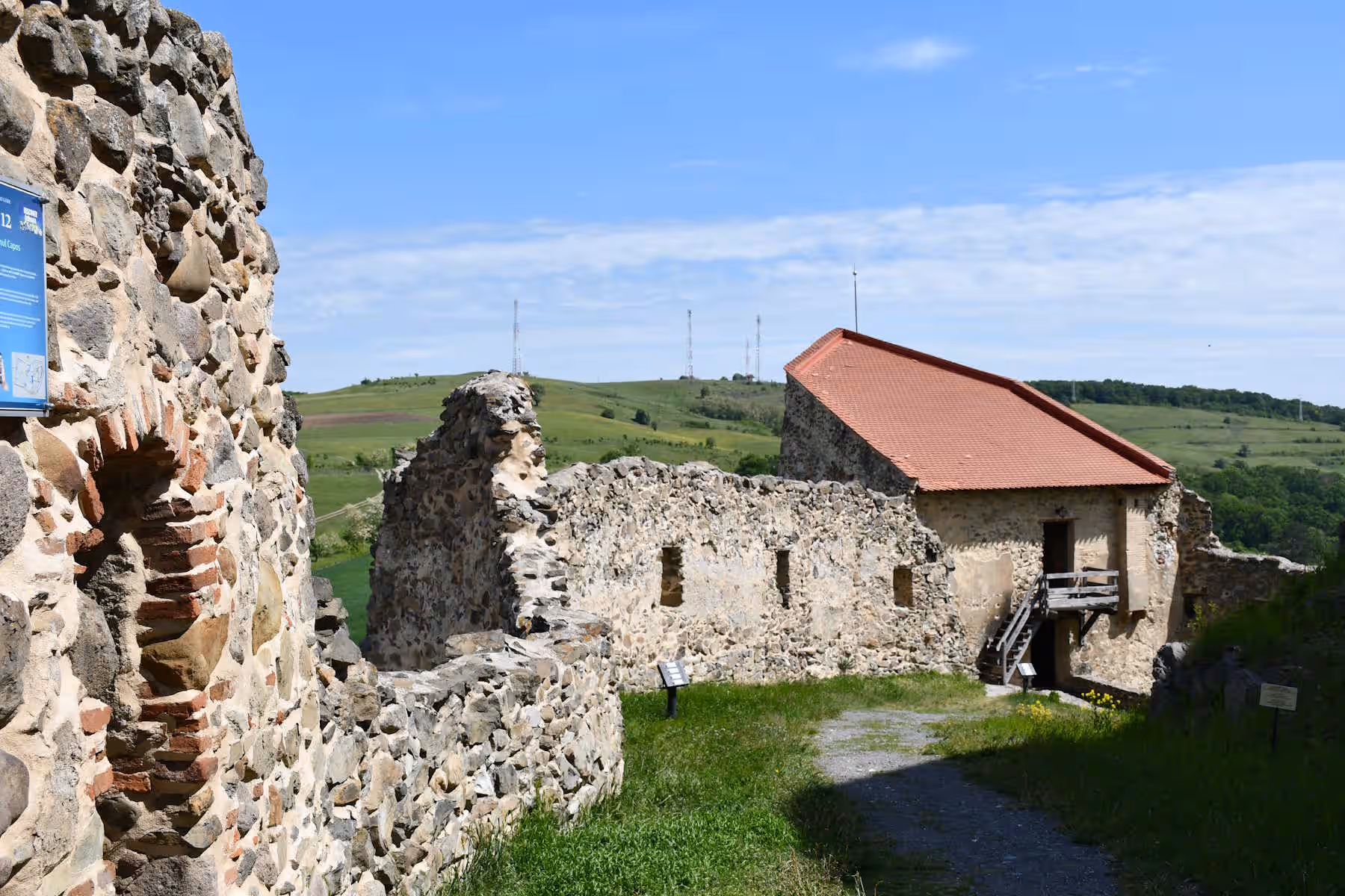 Ruinele zidurilor și casa restaurată din Cetatea Rupea