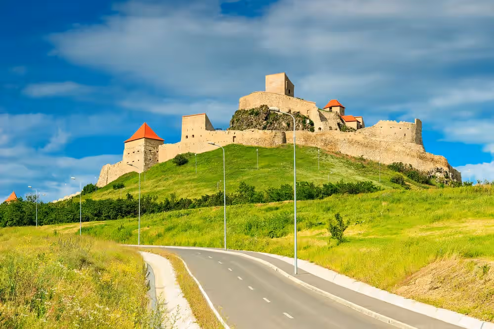 Drumul spre Cetatea Rupea printre pajiști verzi