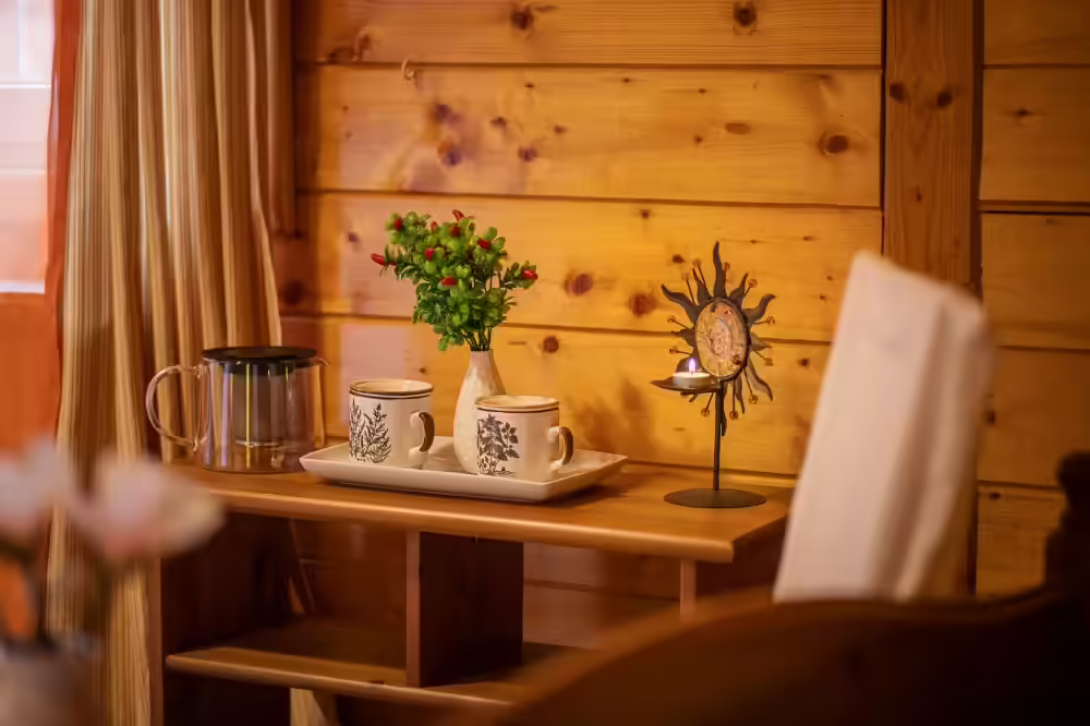 Colț de mic dejun cu masă din lemn și ceainic la Ohana Boutique Hotel