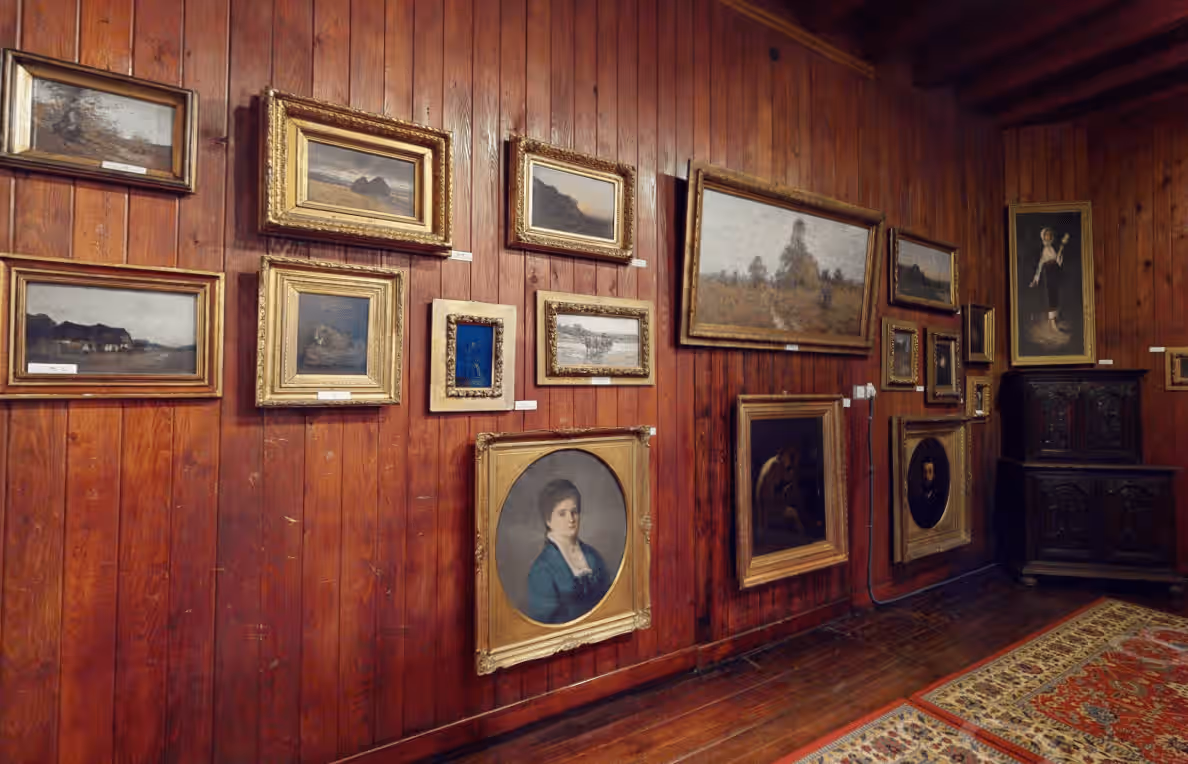 Salon cu lambriuri de lemn și tablouri de Nicolae Grigorescu