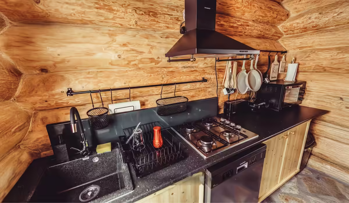 Bucătărie complet utilată cu plită și hotă la Cabana Alaska, Rânca