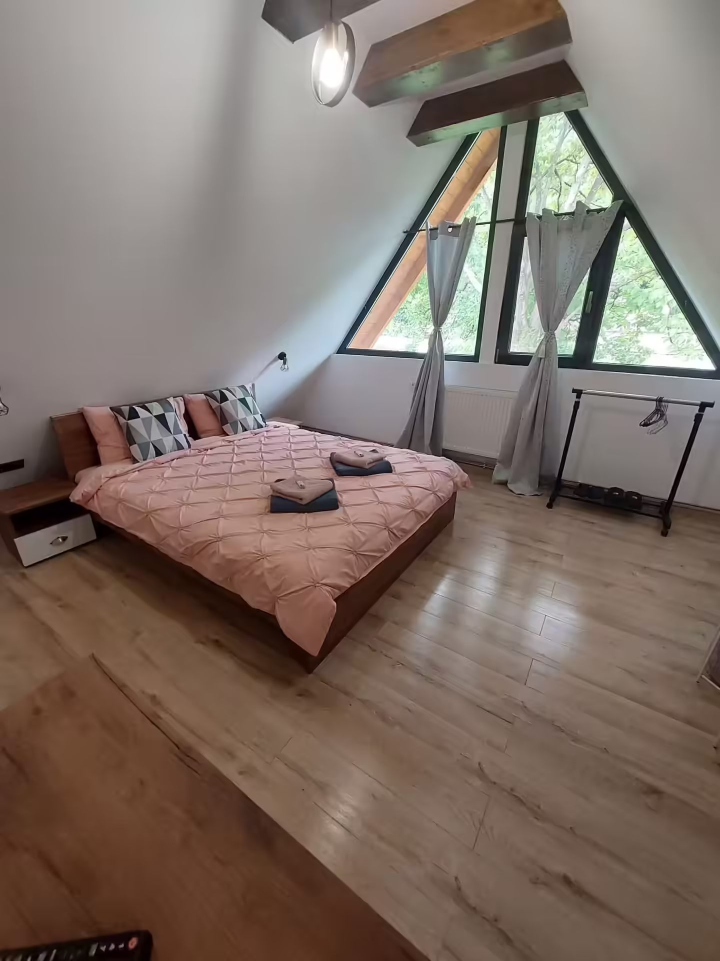 Dormitor roz cu fereastră triunghiulară la Cabana A-frame Nis Dormitor roz cu fereastră triunghiulară la Cabana A-frame Nis