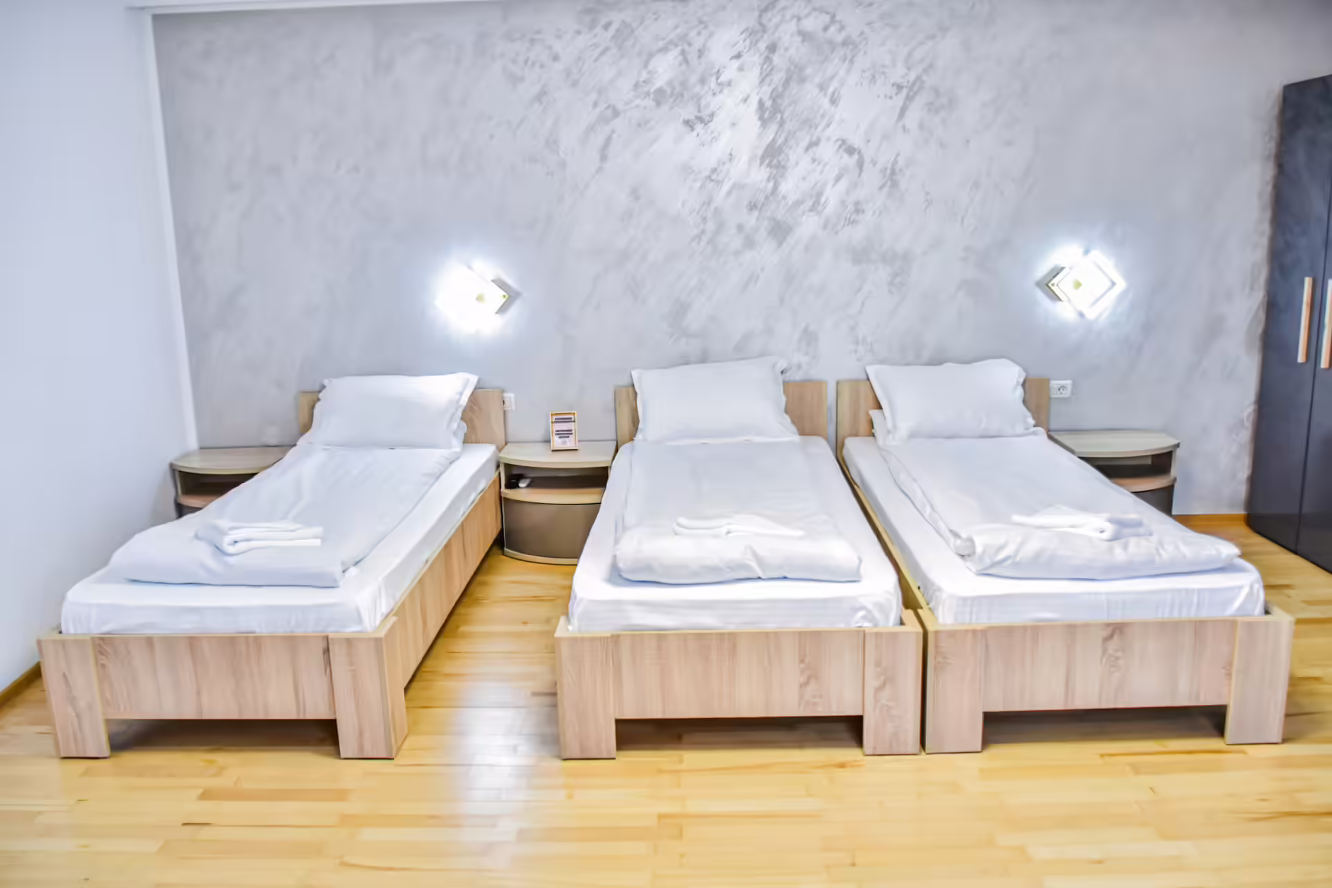 Cameră cu trei paturi și decor modern la Random House Cameră cu trei paturi și decor modern la Random House