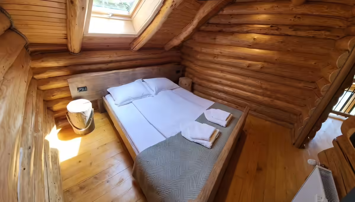 Dormitor la mansardă cu pat matrimonial și pereți din lemn rotund, Cacica Hill Dormitor la mansardă cu pat matrimonial și pereți din lemn rotund, Cacica Hill