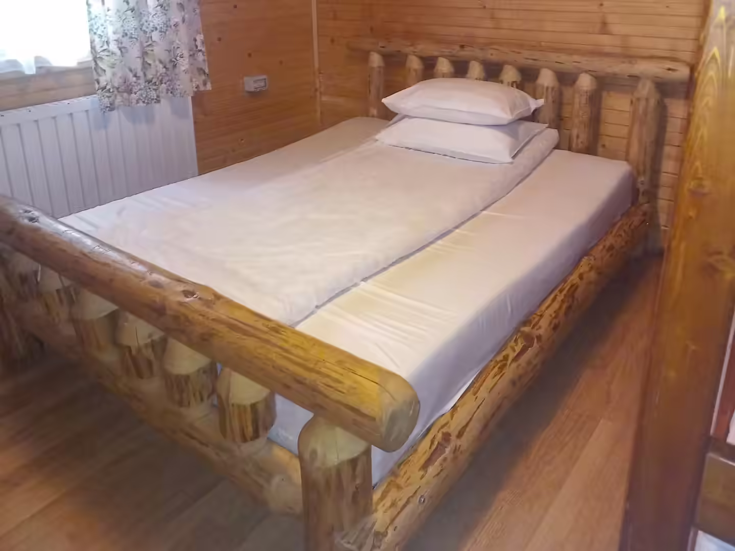 Dormitor cu pat din lemn masiv la Cabana din Pădurea Beliș
