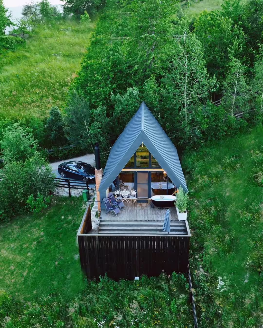 Vedere aeriană a cabanei A-frame cu ciubăr de la La Noi La Munte, Munții Apuseni Vedere aeriană a cabanei A-frame cu ciubăr de la La Noi La Munte, Munții Apuseni