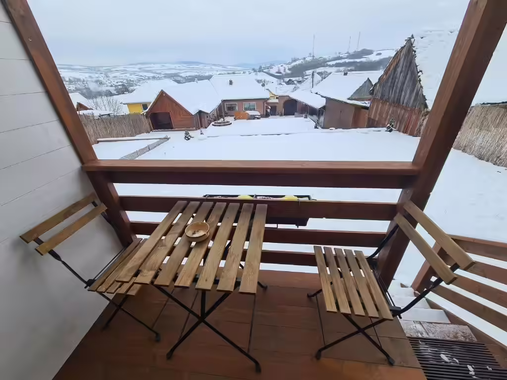 Terasa Flori Haus Saschiz iarna, cu vedere spre satul acoperit de zăpadă Terasa Flori Haus Saschiz iarna, cu vedere spre satul acoperit de zăpadă