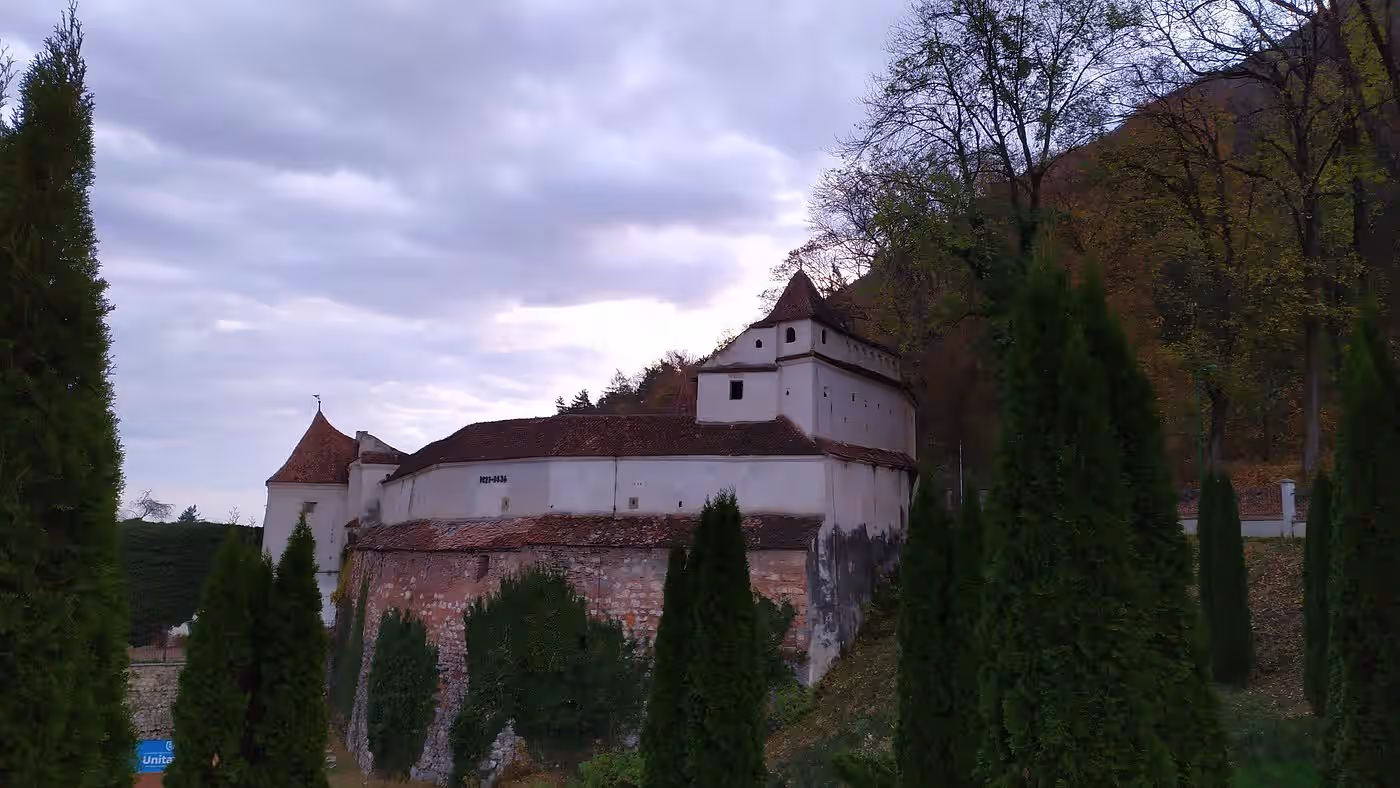 Bastionul Țesătorilor printre chiparoși, la poalele Tâmpei