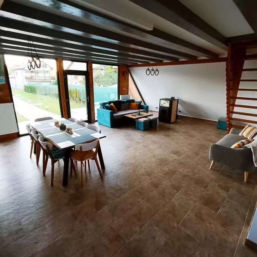 Living și sufragerie cu ferestre panoramice la Cabana A-frame Nis Living și sufragerie cu ferestre panoramice la Cabana A-frame Nis